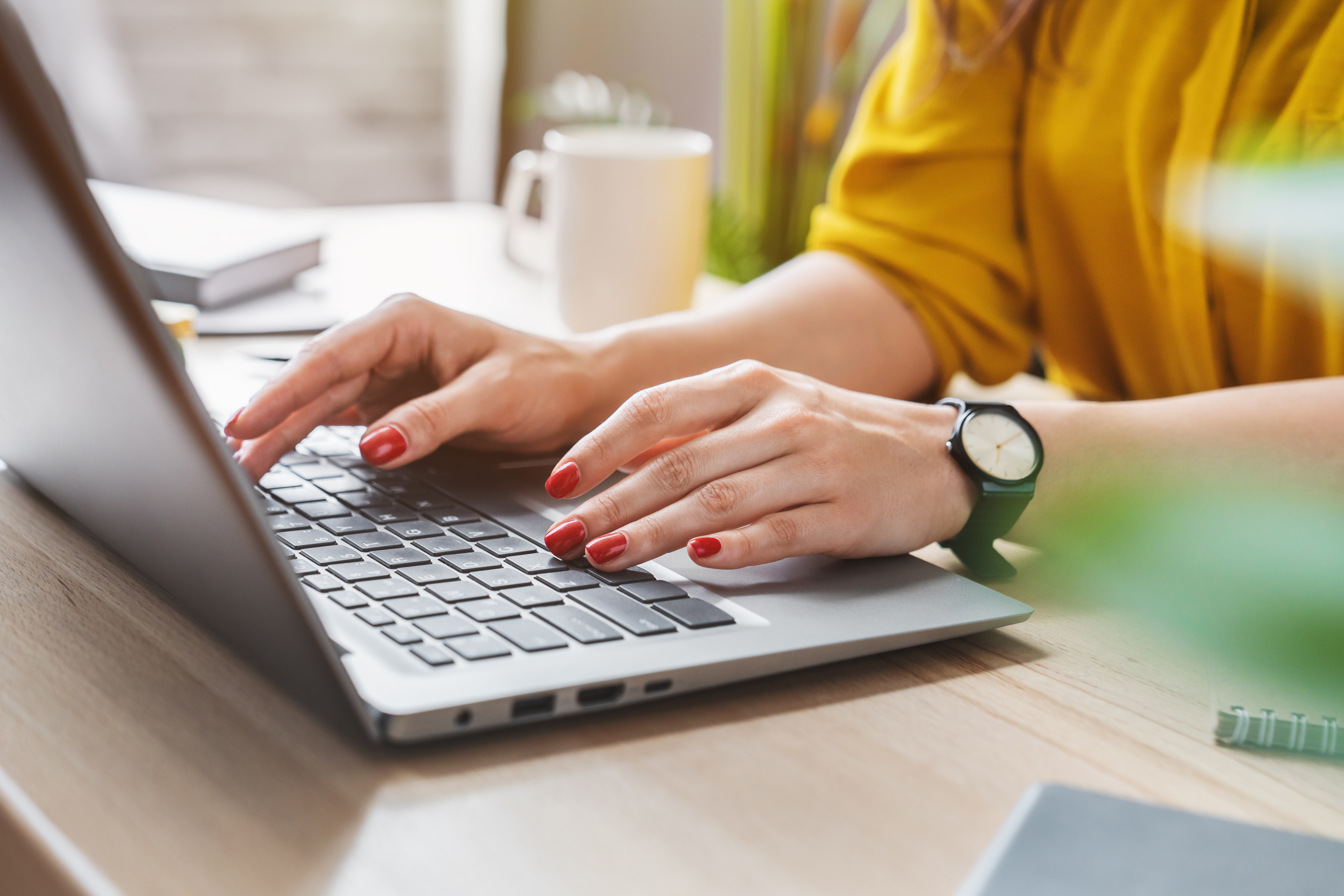 Business woman typing on laptop in her home office.